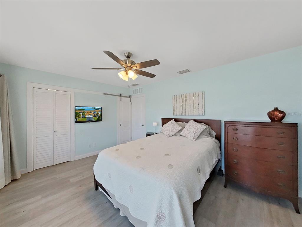 825 East Gulf Boulevard, Unit 110 Indian Rocks Beach, FL 33785 - Photo 41 of 75 a bedroom with a bed and a chandelier