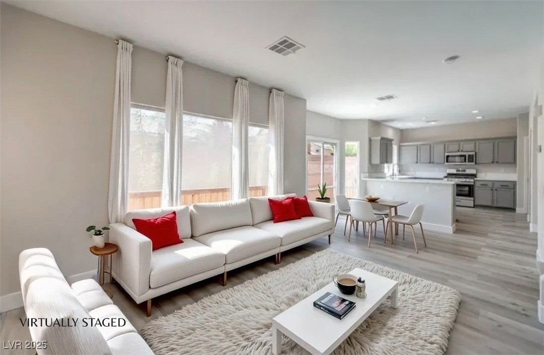 979 Park Bridge Avenue Las Vegas, NV 89123 - Photo 13 of 57 Living room with light wood-style floors and baseboards