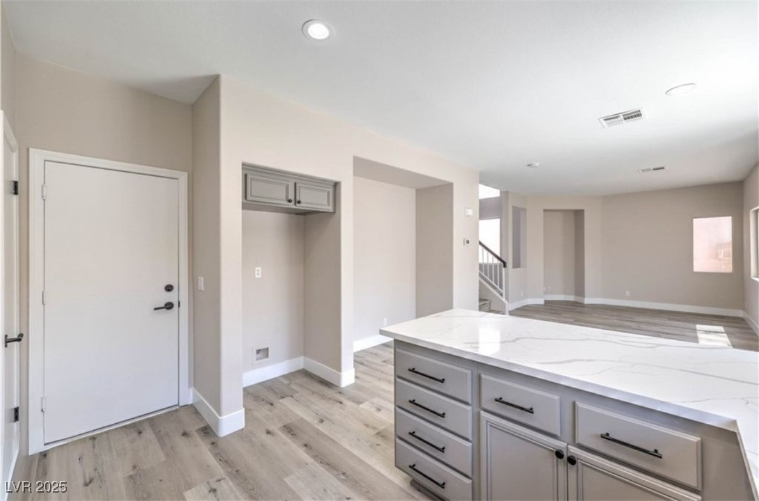 979 Park Bridge Avenue Las Vegas, NV 89123 - Photo 57 of 57 Kitchen with gray cabinets, light stone countertops, light wood-type flooring, recessed lighting, and open floor plan