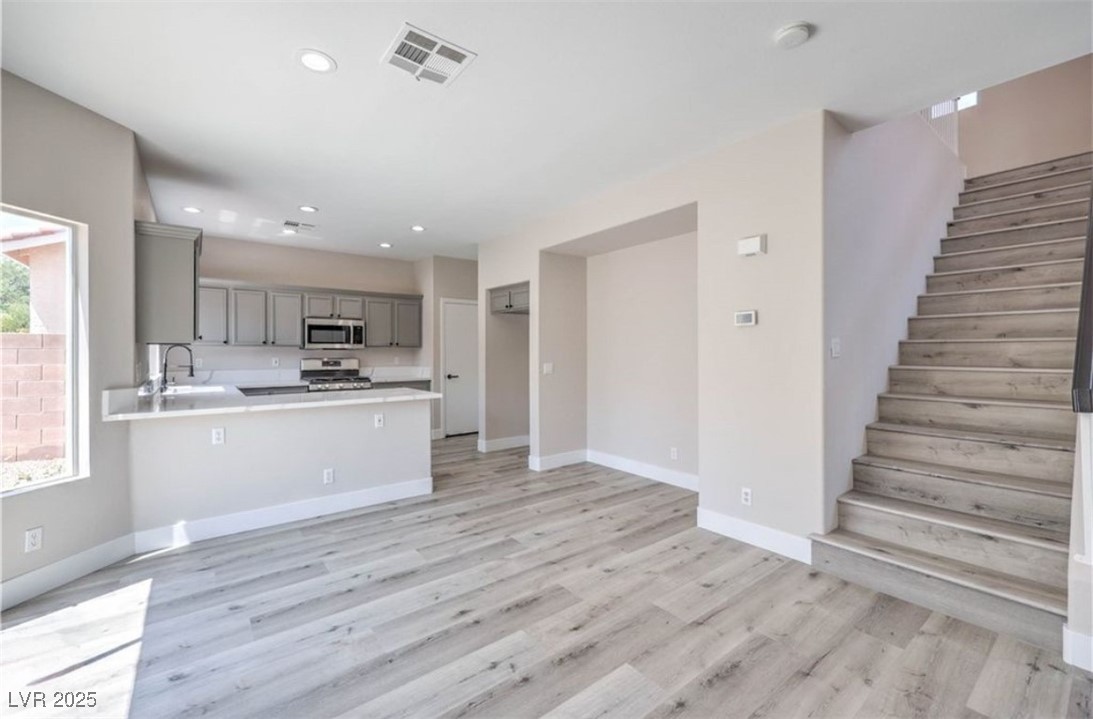 979 Park Bridge Avenue Las Vegas, NV 89123 - Photo 18 of 57 Unfurnished living room featuring light wood-style flooring, stairway, and recessed lighting