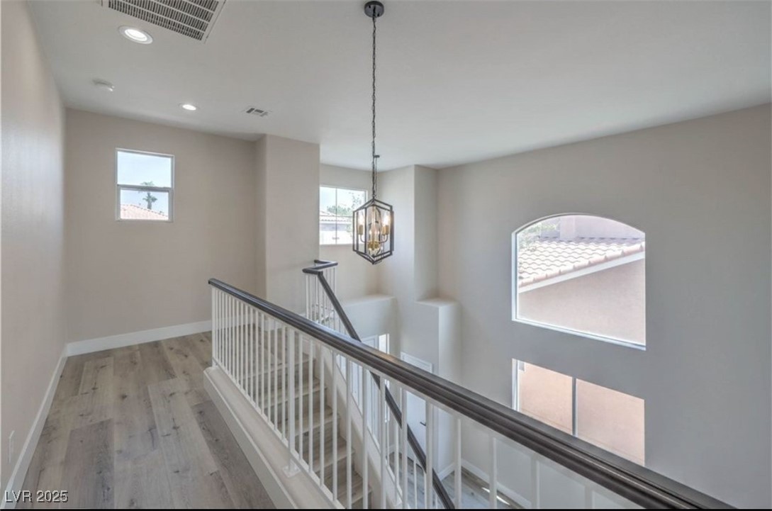 979 Park Bridge Avenue Las Vegas, NV 89123 - Photo 21 of 57 Hallway with recessed lighting, light wood-style flooring, an upstairs landing, and a chandelier