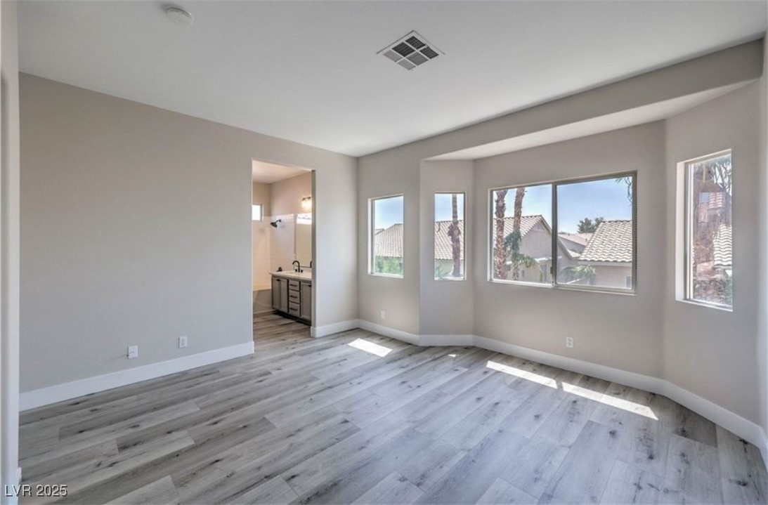 979 Park Bridge Avenue Las Vegas, NV 89123 - Photo 22 of 57 Unfurnished bedroom featuring ensuite bathroom and light wood-style flooring