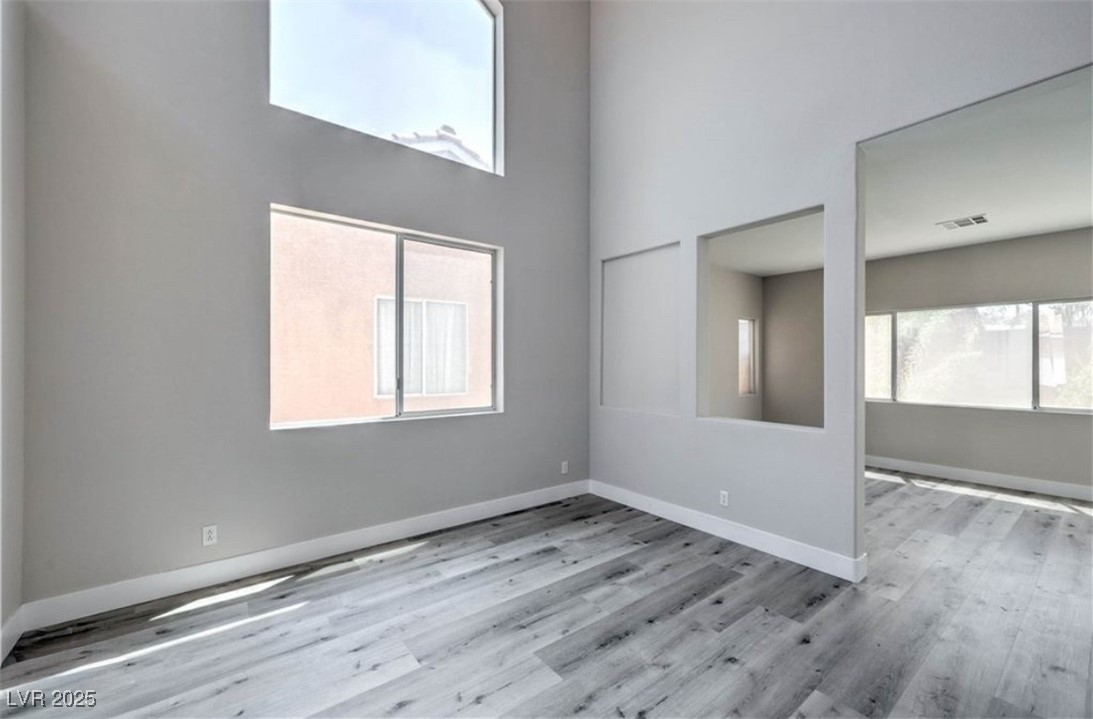 979 Park Bridge Avenue Las Vegas, NV 89123 - Photo 10 of 57 Spare room with a high ceiling and light wood-style flooring