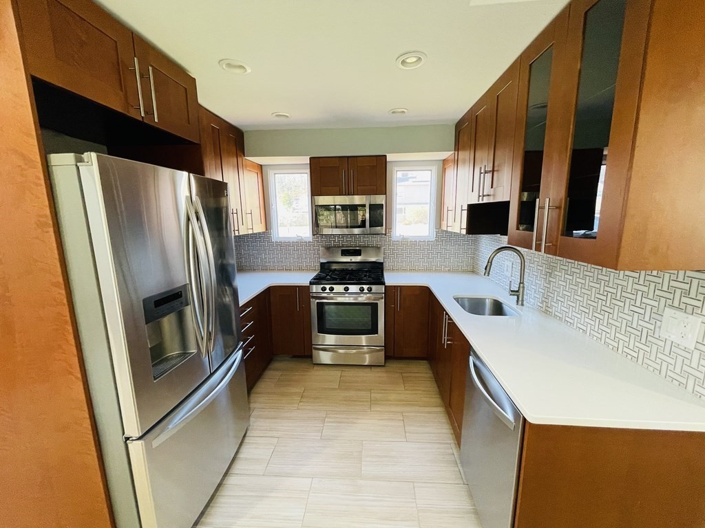 a kitchen with granite countertop a refrigerator and a sink
