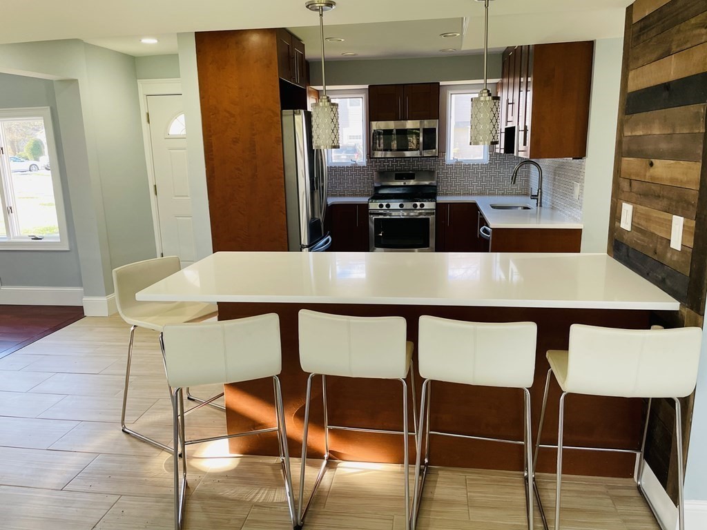 11 Hardwick Road Natick, MA 01760 - Photo 3 of 16 a kitchen with kitchen island a table and chairs in it