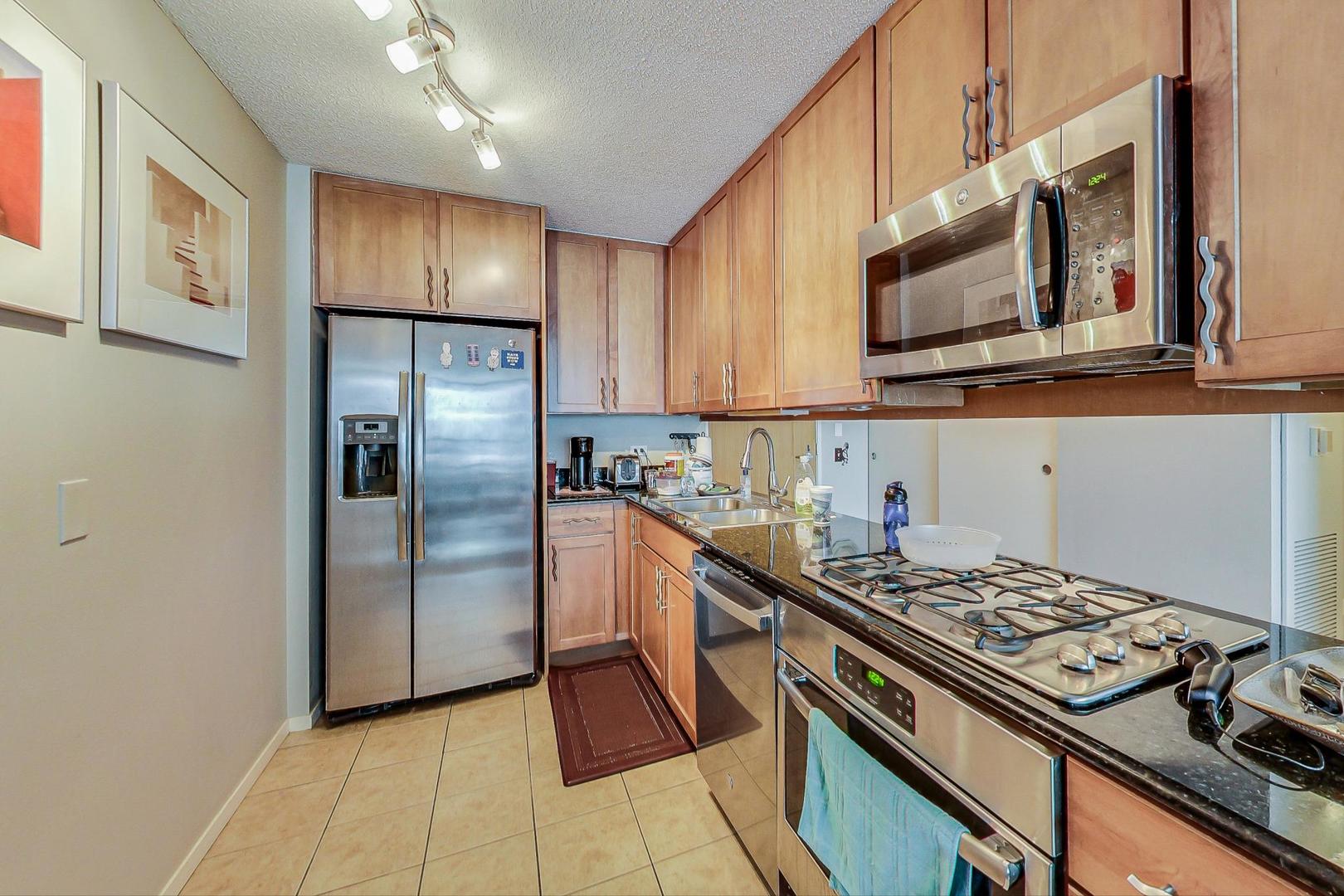 9655 Woods Drive, Unit 1405 Skokie, IL 60077 - Photo 13 of 36 a kitchen with stainless steel appliances granite countertop a stove a refrigerator and a microwave