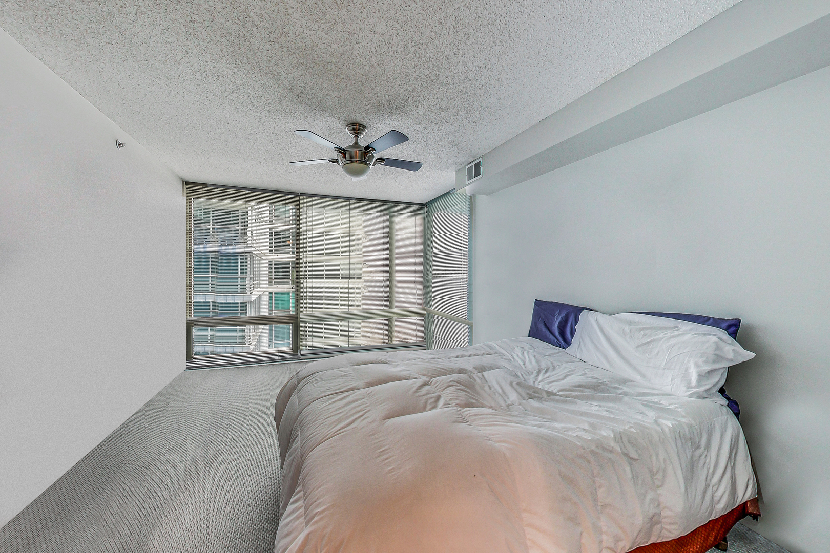9655 Woods Drive, Unit 1405 Skokie, IL 60077 - Photo 16 of 36 a large bed sitting in a bedroom next to a window