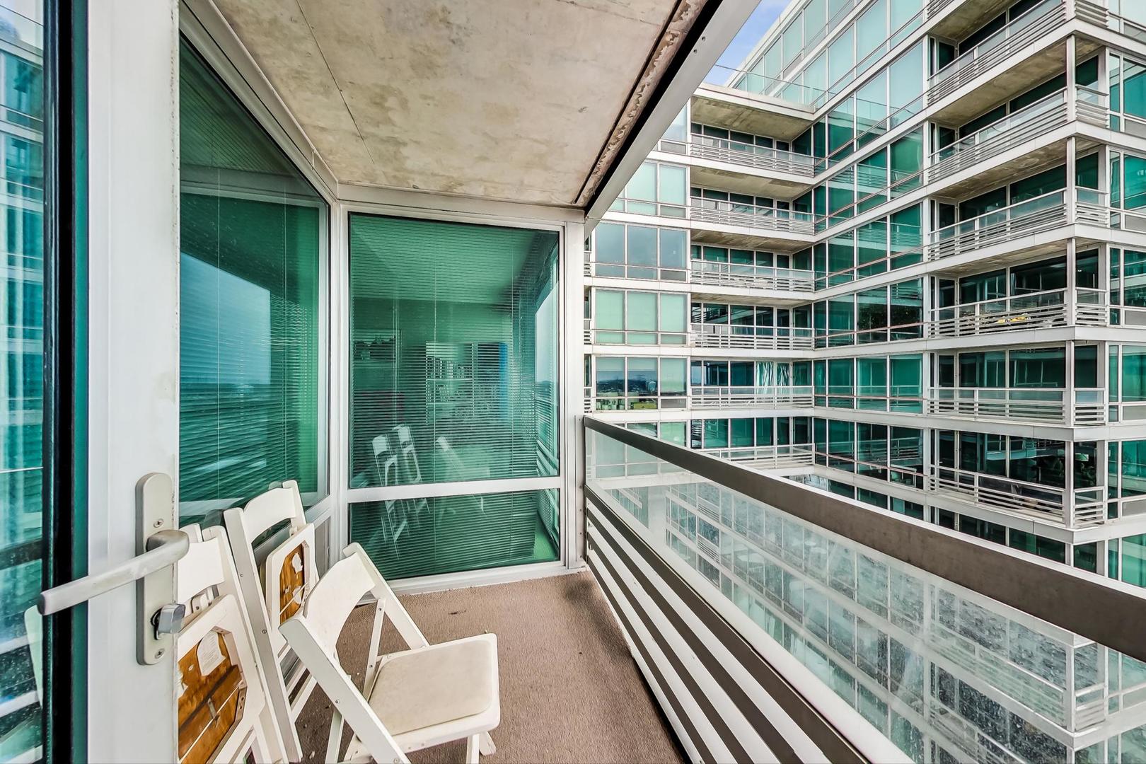 9655 Woods Drive, Unit 1405 Skokie, IL 60077 - Photo 24 of 36 a view of a balcony with a large window and wooden floor