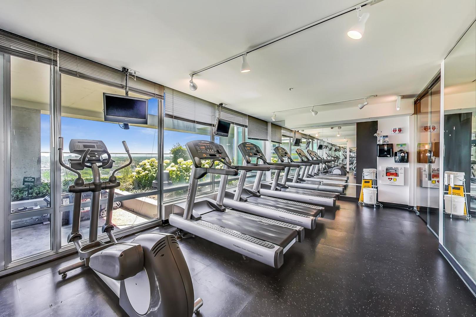9655 Woods Drive, Unit 1405 Skokie, IL 60077 - Photo 30 of 36 a living room with lots of furniture and a chandelier