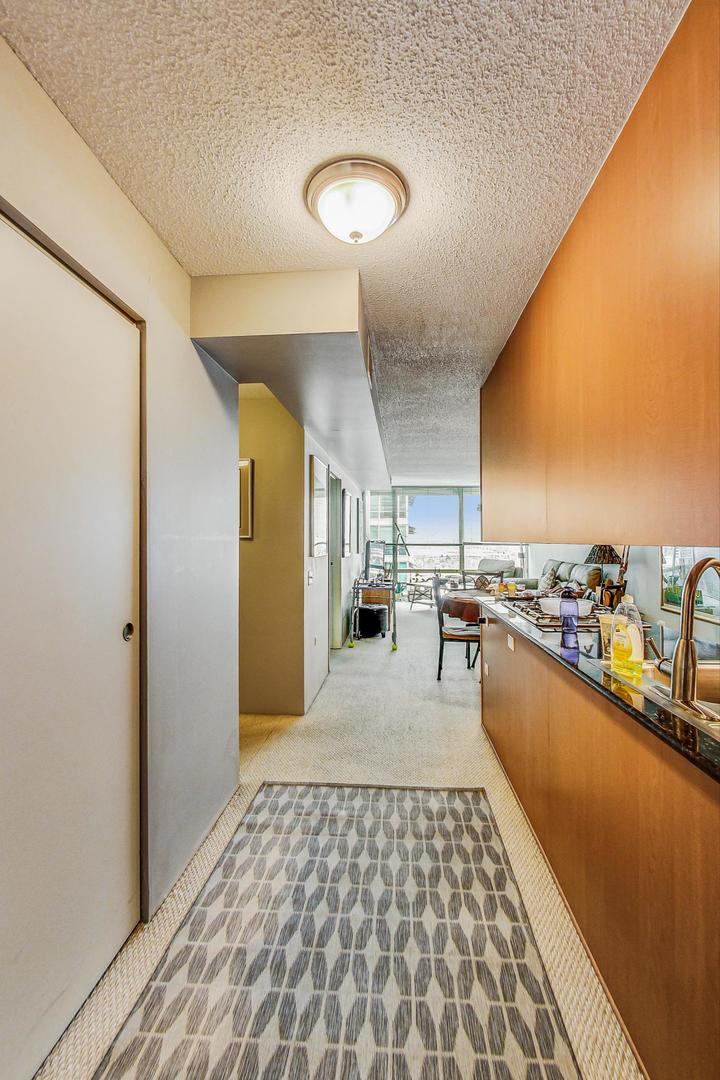9655 Woods Drive, Unit 1405 Skokie, IL 60077 - Photo 8 of 36 a hallway with a large dining table and a stove