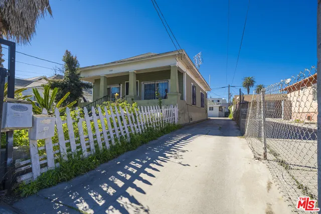 a view of a house with a small yard and wooden fence