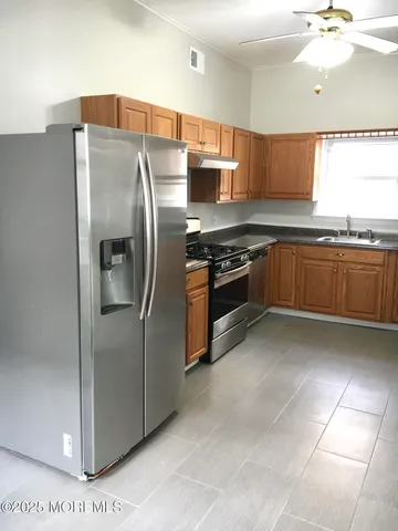 a kitchen with stainless steel appliances granite countertop a refrigerator and a stove