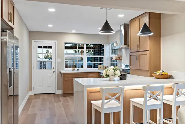 a kitchen with stainless steel appliances granite countertop a refrigerator and a stove top oven