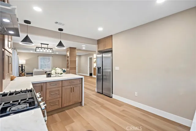 a large kitchen with a large counter top space stainless steel appliances and cabinets