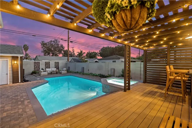 a view of a swimming pool with a patio and furniture