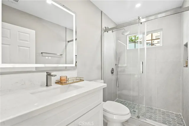 a bathroom with a sink a toilet and shower