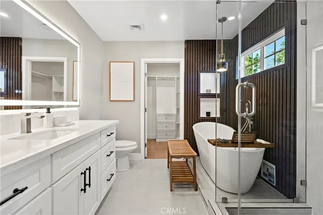 a bathroom with a sink a toilet a mirror and window