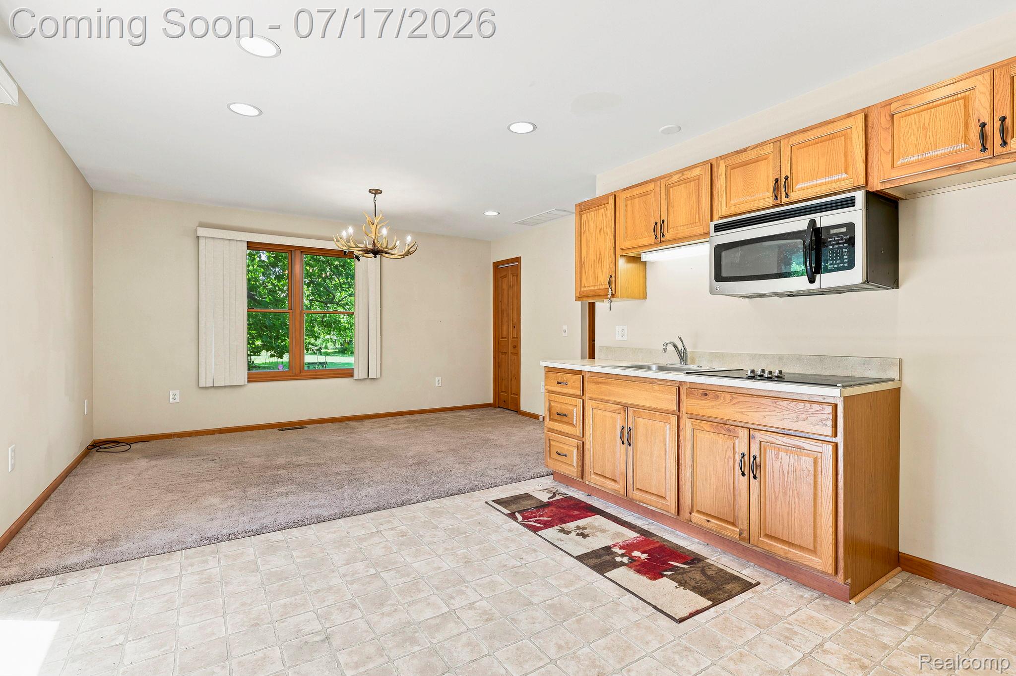 9805 Dolan Road Columbus, MI 48063 - Photo 18 of 39 Kitchenette featuring wood cabinetry, laminate countertops, stainless steel microwave, and integrated sink