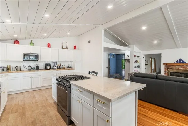 a kitchen with stainless steel appliances kitchen island granite countertop a dining table and chairs