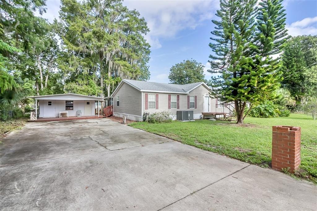 56449 Elm Road Astor, FL 32102 - Photo 1 of 1 a front view of a house with a yard and a garage