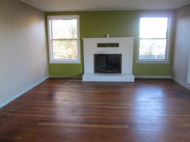 120 Freeman Road Central Point, OR 97502 - Photo 14 of 16 an empty room with wooden floor a fireplace and windows