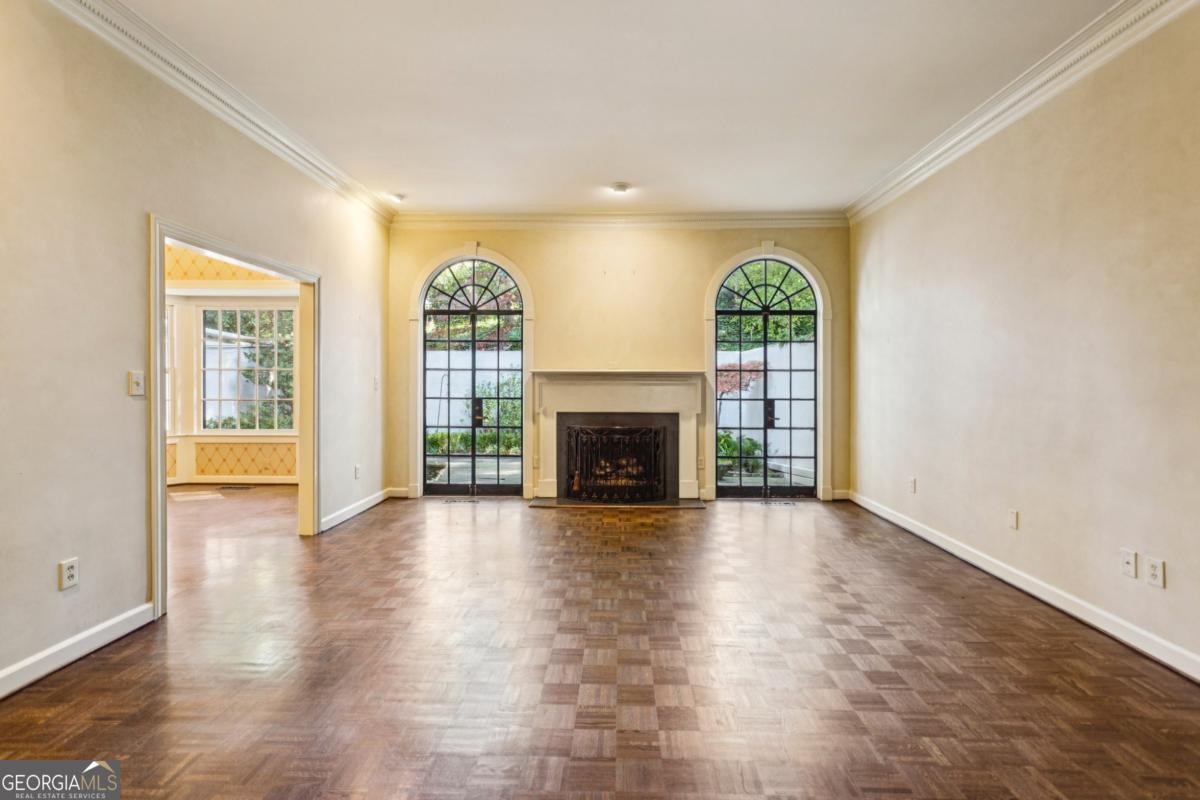19 Mooregate Square Northwest Atlanta, GA 30327 - Photo 14 of 48 an empty room with windows fireplace and wooden floor