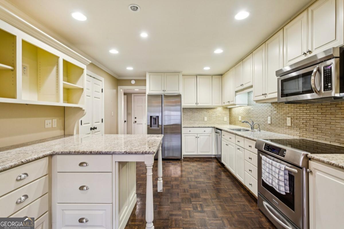 19 Mooregate Square Northwest Atlanta, GA 30327 - Photo 19 of 48 a kitchen with granite countertop a sink stainless steel appliances and cabinets