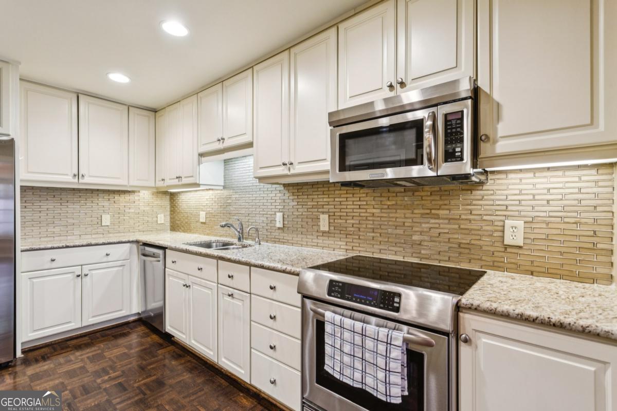 19 Mooregate Square Northwest Atlanta, GA 30327 - Photo 22 of 48 a kitchen with granite countertop cabinets stainless steel appliances and a sink