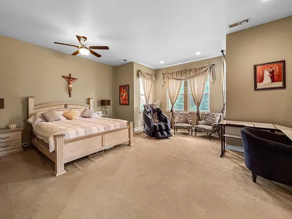 a bedroom with a bed gym equipment and a large window