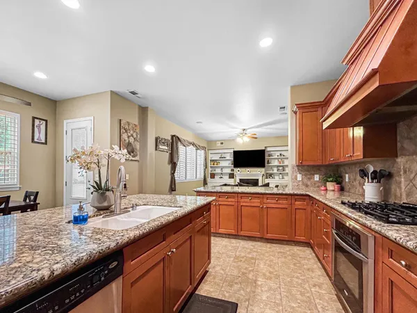 a large kitchen with stainless steel appliances granite countertop a sink stove and cabinets