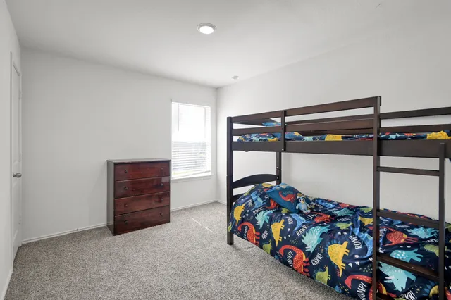 a bedroom with bunk bed and a window