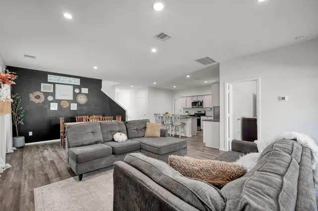 a living room with furniture and a view of kitchen