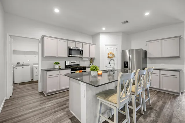 a kitchen with white cabinets and stainless steel appliances