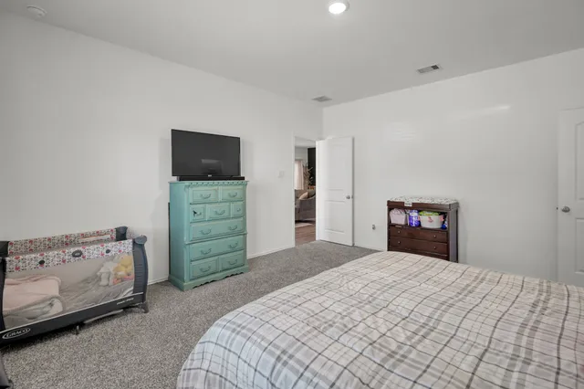 a bedroom with a bed and a tv on the dresser