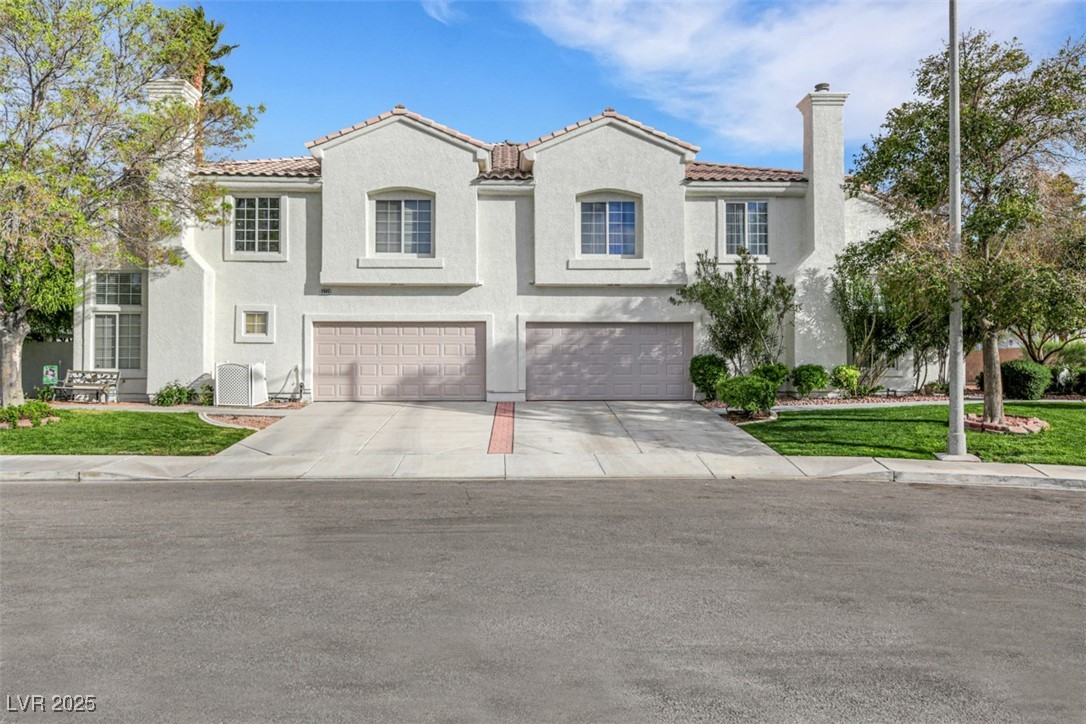 2907 Rio Sonora Court Henderson, NV 89074 - Photo 2 of 35 Mediterranean / spanish-style house with a chimney, a front lawn, driveway, stucco siding, and an attached garage