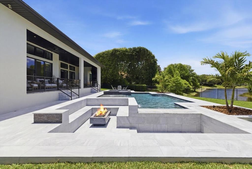 2829 Coastal Range Way Lutz, FL 33559 - Photo 56 of 64 a view of a swimming pool with an outdoor seating and a garden
