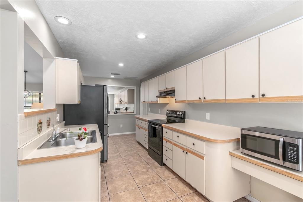 10 Carry Back Road Ocala, FL 34482 - Photo 19 of 69 a kitchen with stainless steel appliances granite countertop a sink stove refrigerator and cabinets