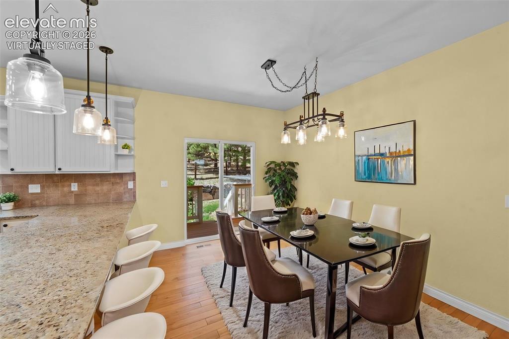16540 Mesquite Road Peyton, CO 80831 - Photo 14 of 50 a view of a dining room with furniture wooden floor and chandelier