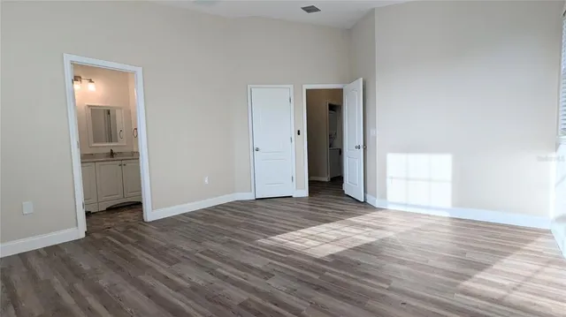 a view of an empty room and window and wooden floor
