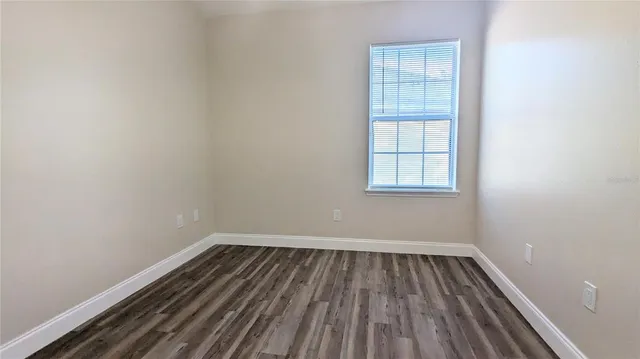 a view of a room with wooden floor and window