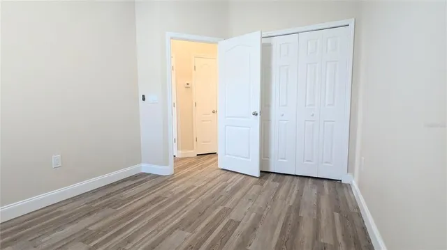 a view of wooden floor and closet in a room