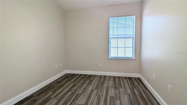 a view of a room with wooden floor and window