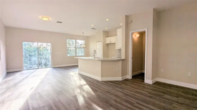 a view of a kitchen with wooden floor and a window