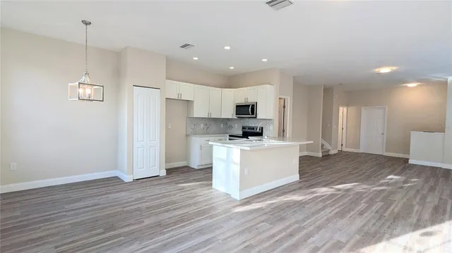 a view of kitchen with refrigerator microwave and stove top oven