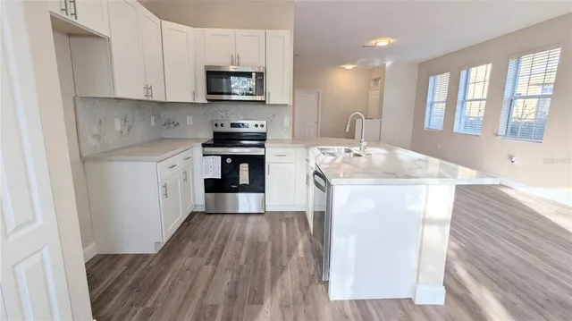 a kitchen with a sink stove and cabinets