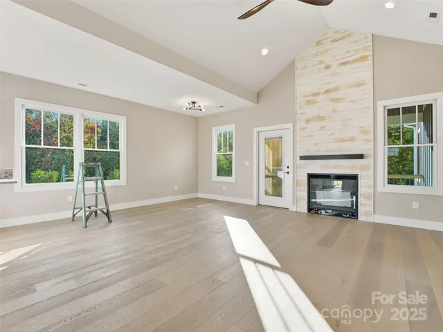 a view of an empty room with a fireplace and a window