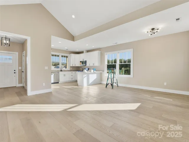 a view of a kitchen with kitchen island a sink wooden floor and counter top space