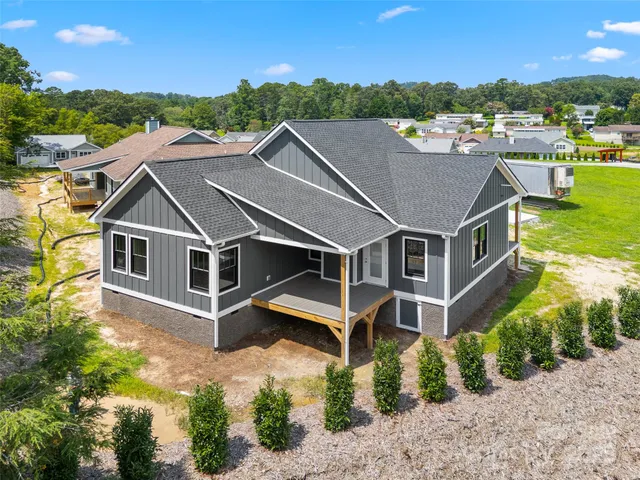 an aerial view of a house with a garden and lake view