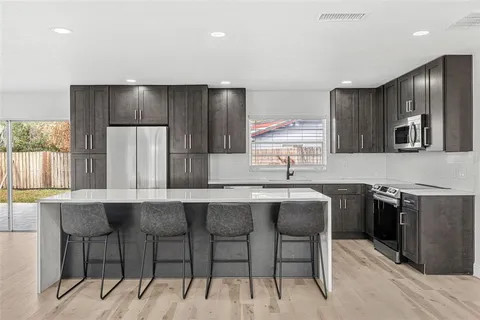 a kitchen with stainless steel appliances a sink stove and cabinets
