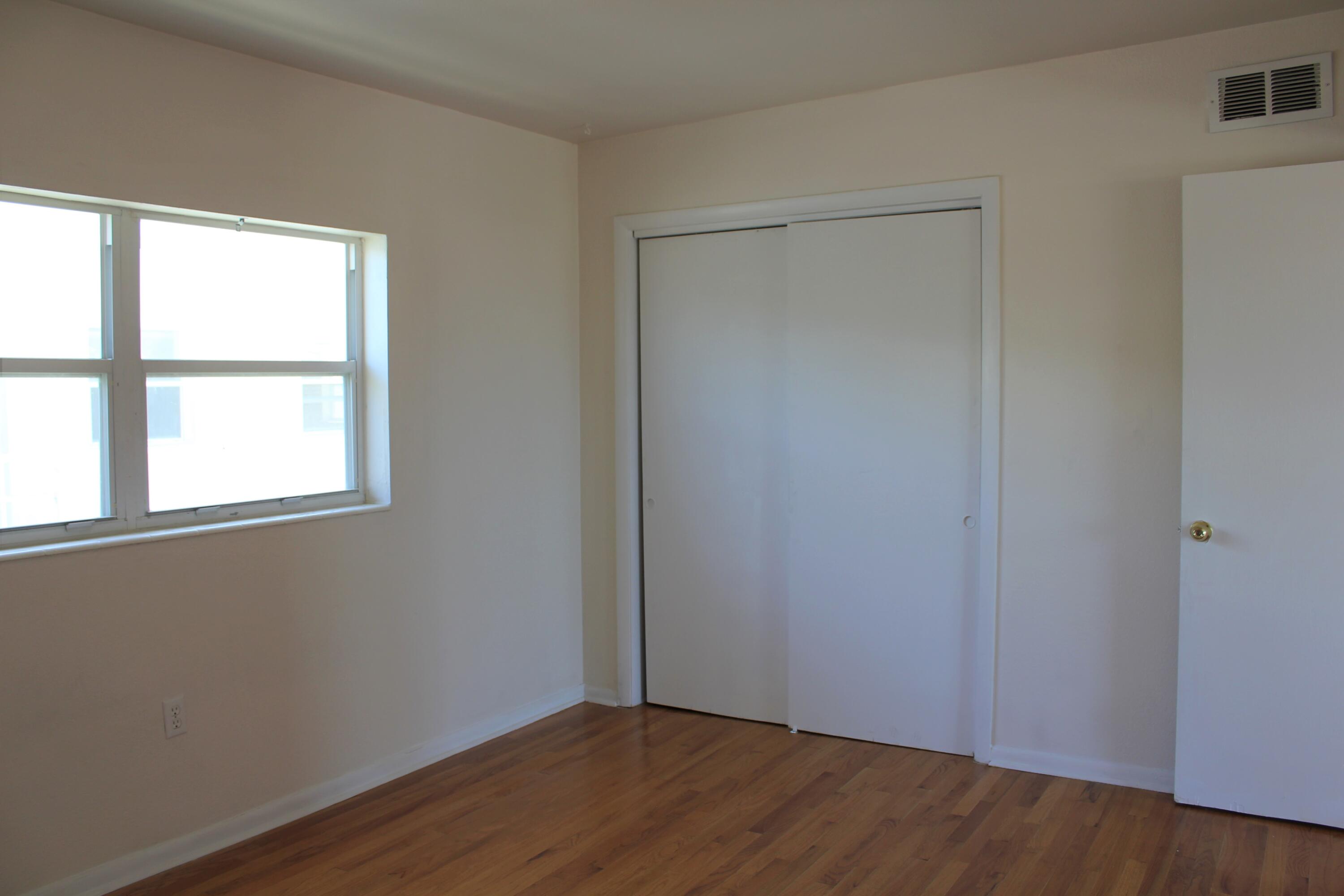 651 Palm Drive, Unit A4 Satellite Beach, FL 32937 - Photo 11 of 16 an empty room with wooden floor and windows